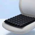 Black 3D honeycomb-style inflatable cushion being pressed to demonstrate air-cell comfort and posture support